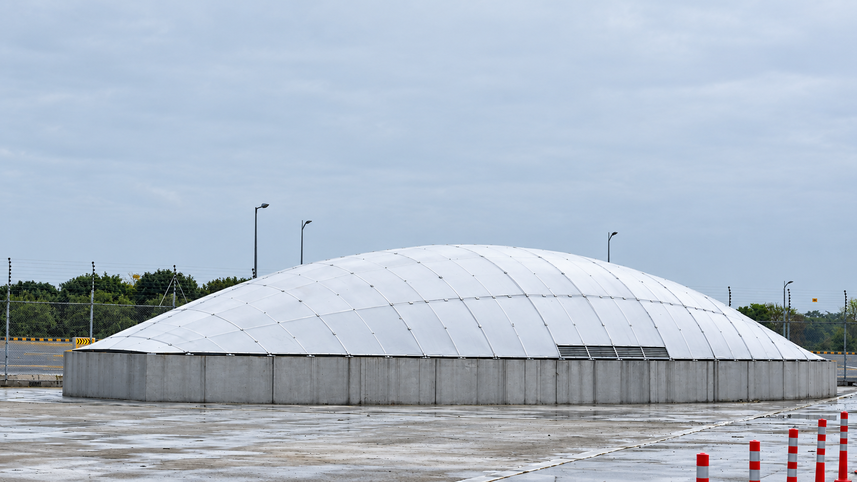 Large translucent polycarbonate dome roof structure glowing under the sky
