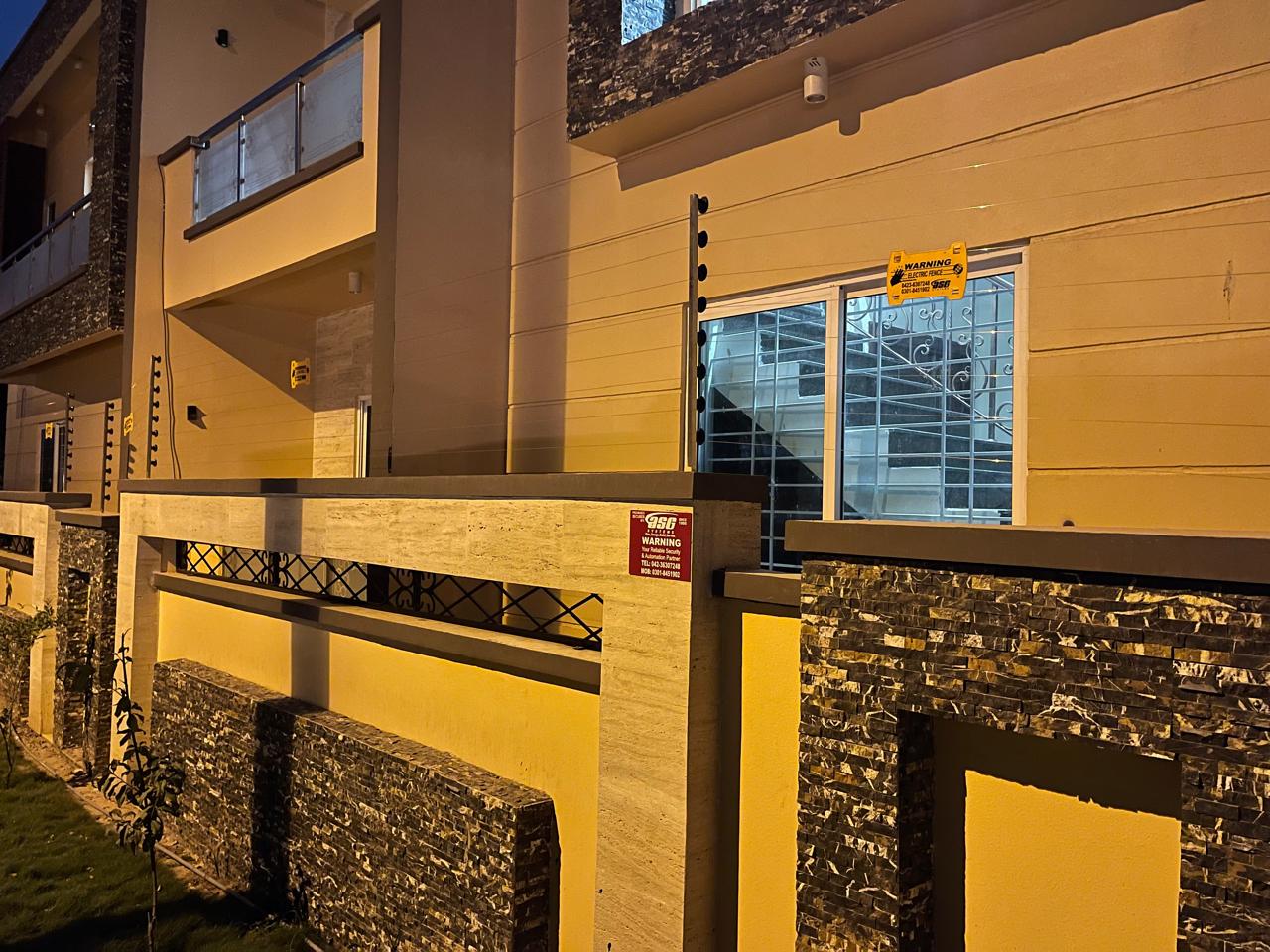 Electric fence along the front and side walls of a residence