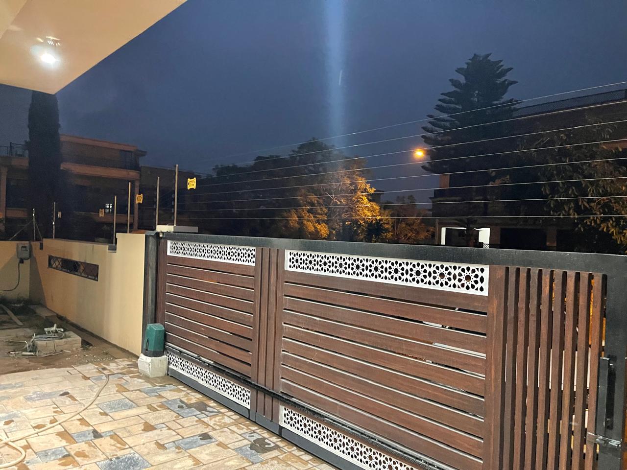 Electric fence on the wall and gate of a house at dusk