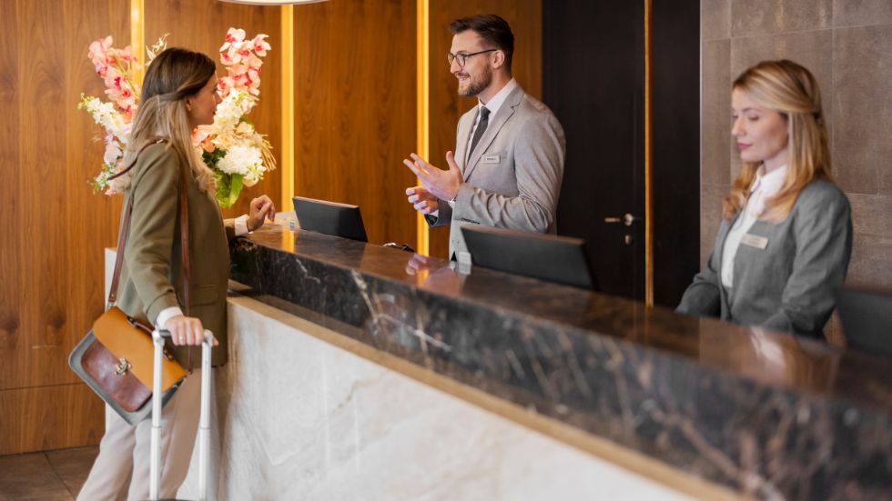 Guest checking in at a hotel reception desk with front desk staff