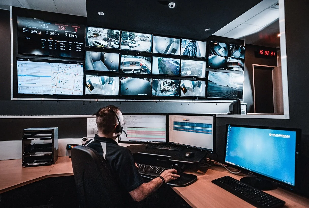 Security operator monitoring CCTV cameras on a video wall in a surveillance control room