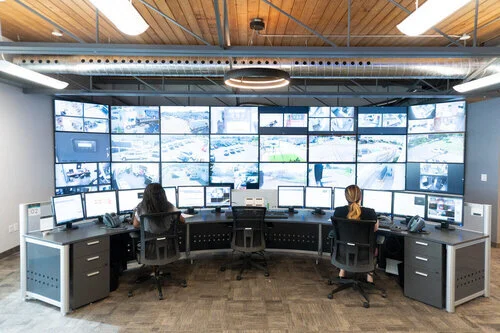 Security command and control room with a video wall and operators monitoring CCTV cameras