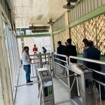 Passengers passing through a security checkpoint at an Orange Line Metro station