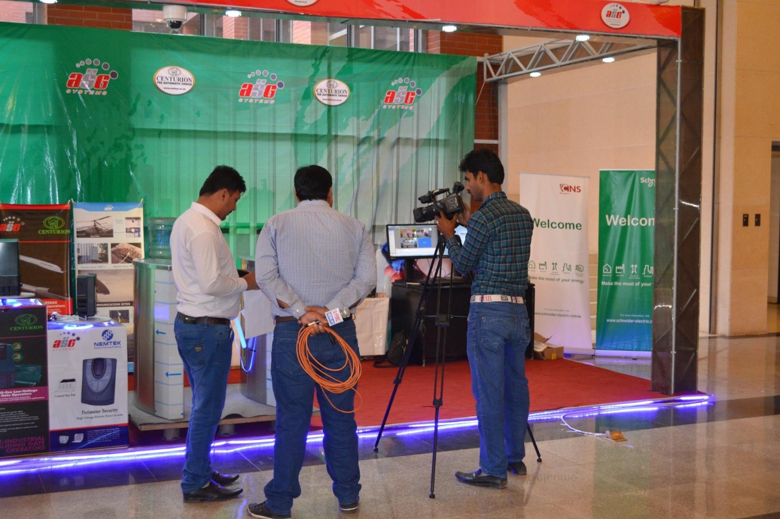 Media crew recording at the ASG Systems stand with gate operators, turnstile and electric fence products