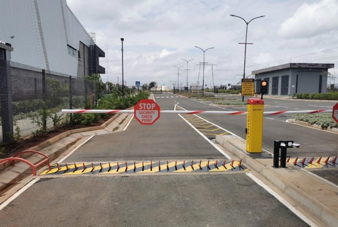 Tyre killer spikes installed with a boom barrier and stop sign at a secured site entrance