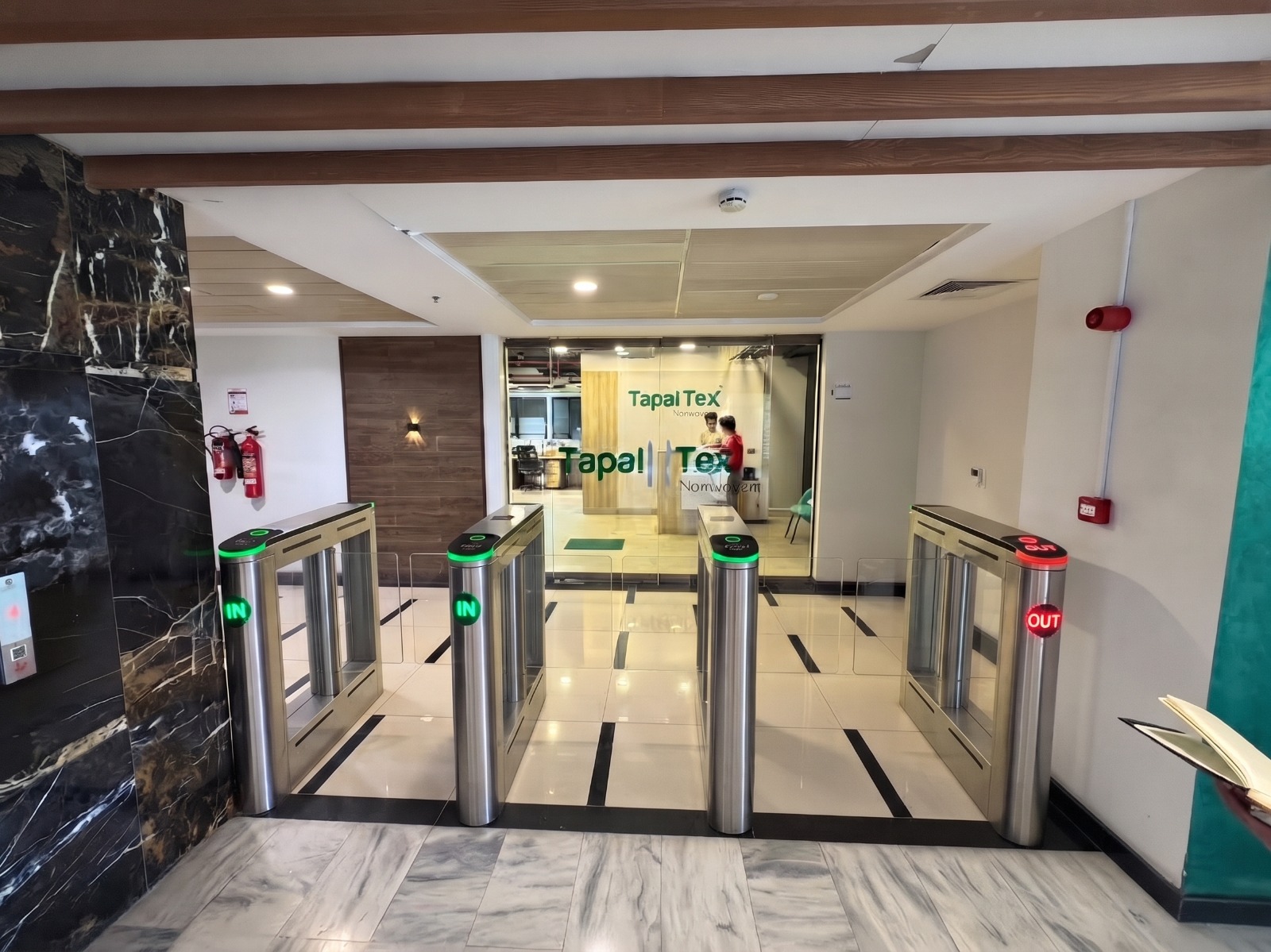 Speed gates with glass wings at the entrance of a corporate office lobby