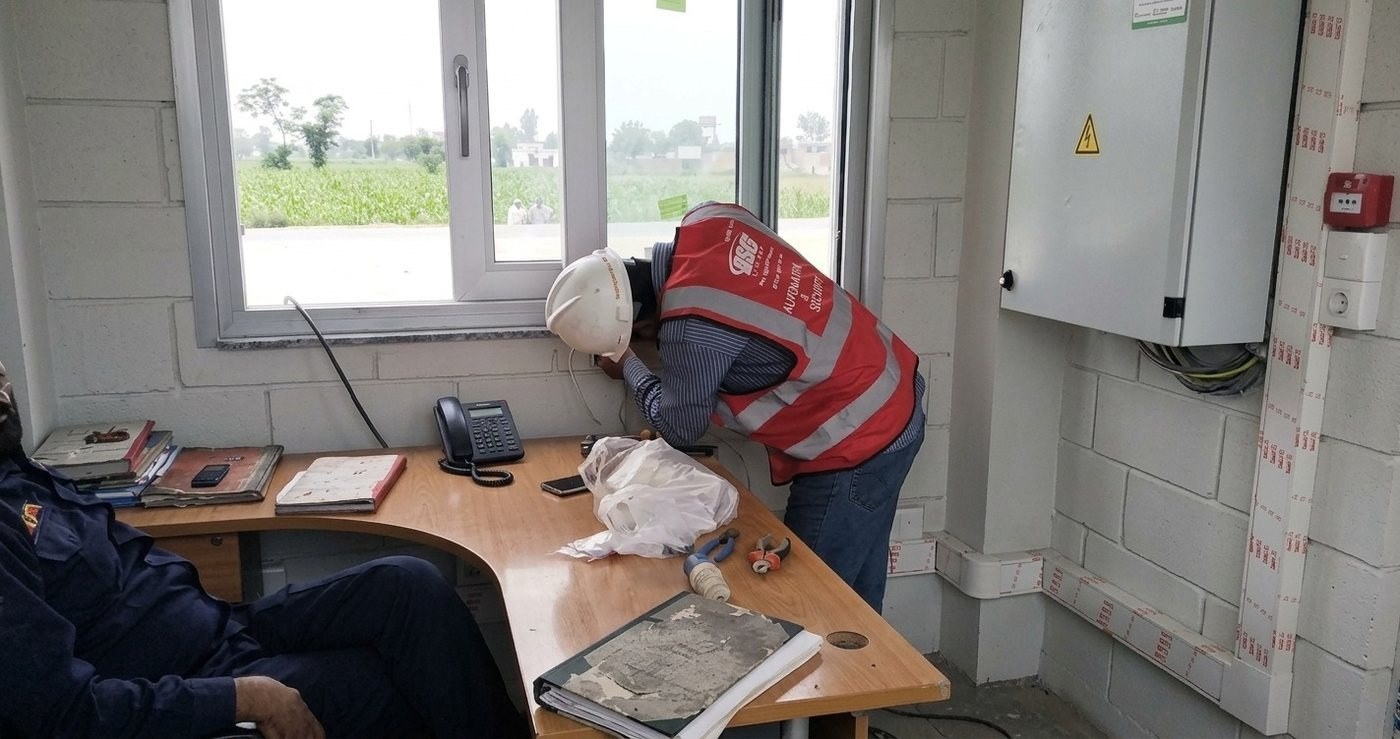 ASG Systems technician commissioning the gate automation control panel at a CCBPL site office