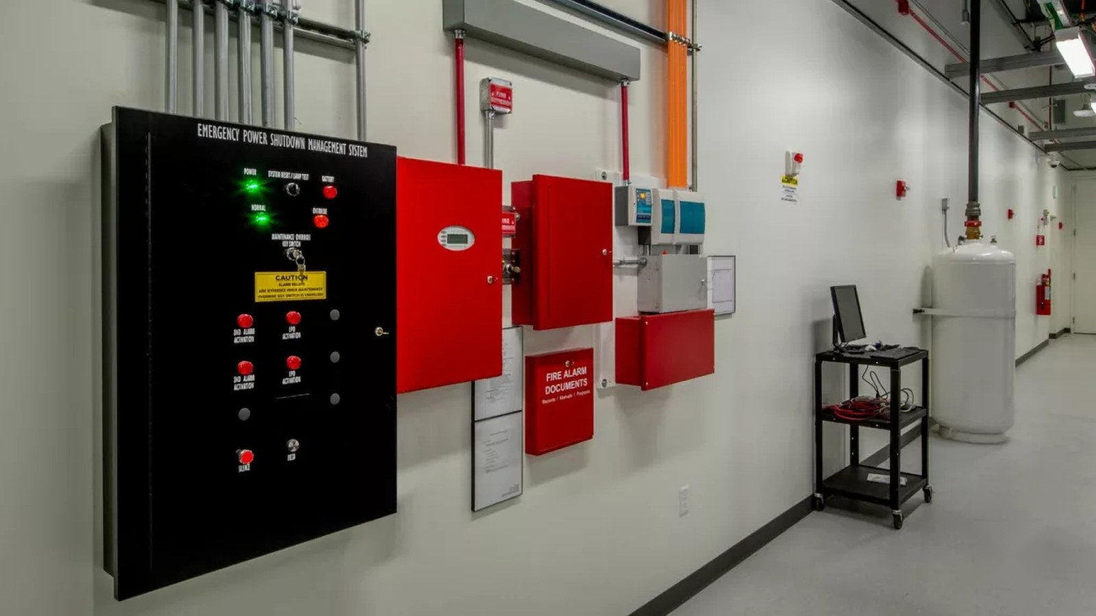 Emergency power shutdown and fire alarm control panels mounted on a plant room wall