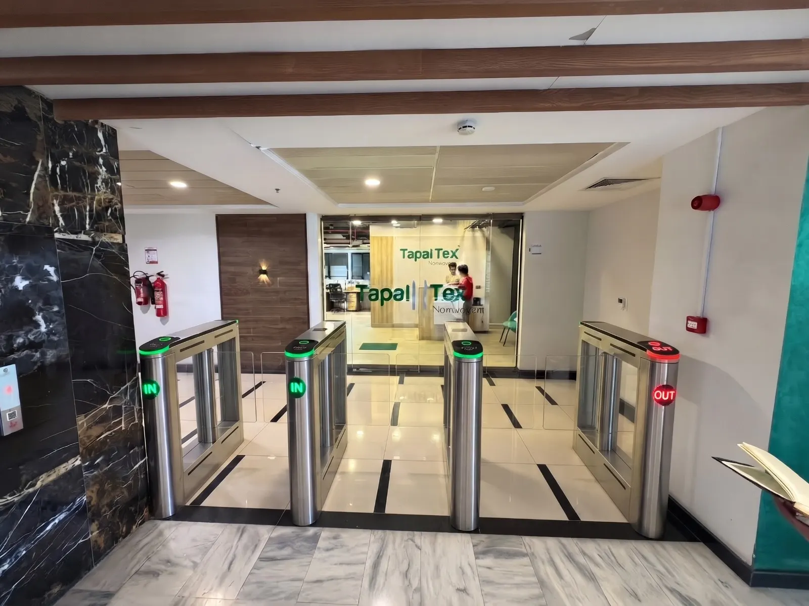 Speed gates with glass wings at the entrance of a corporate office lobby